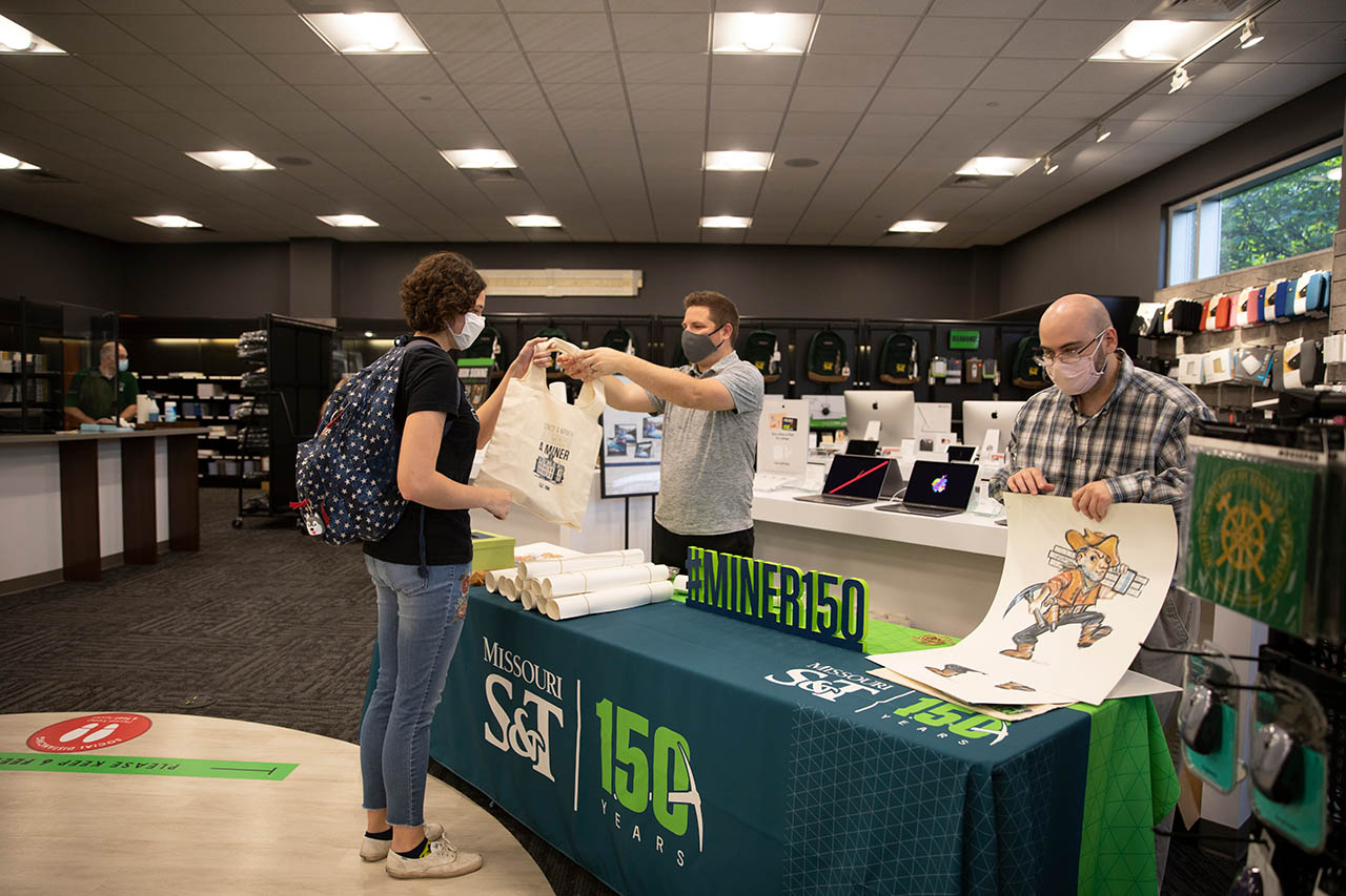 Stutdent receives canvas gift bag from 150 event table in the book store.